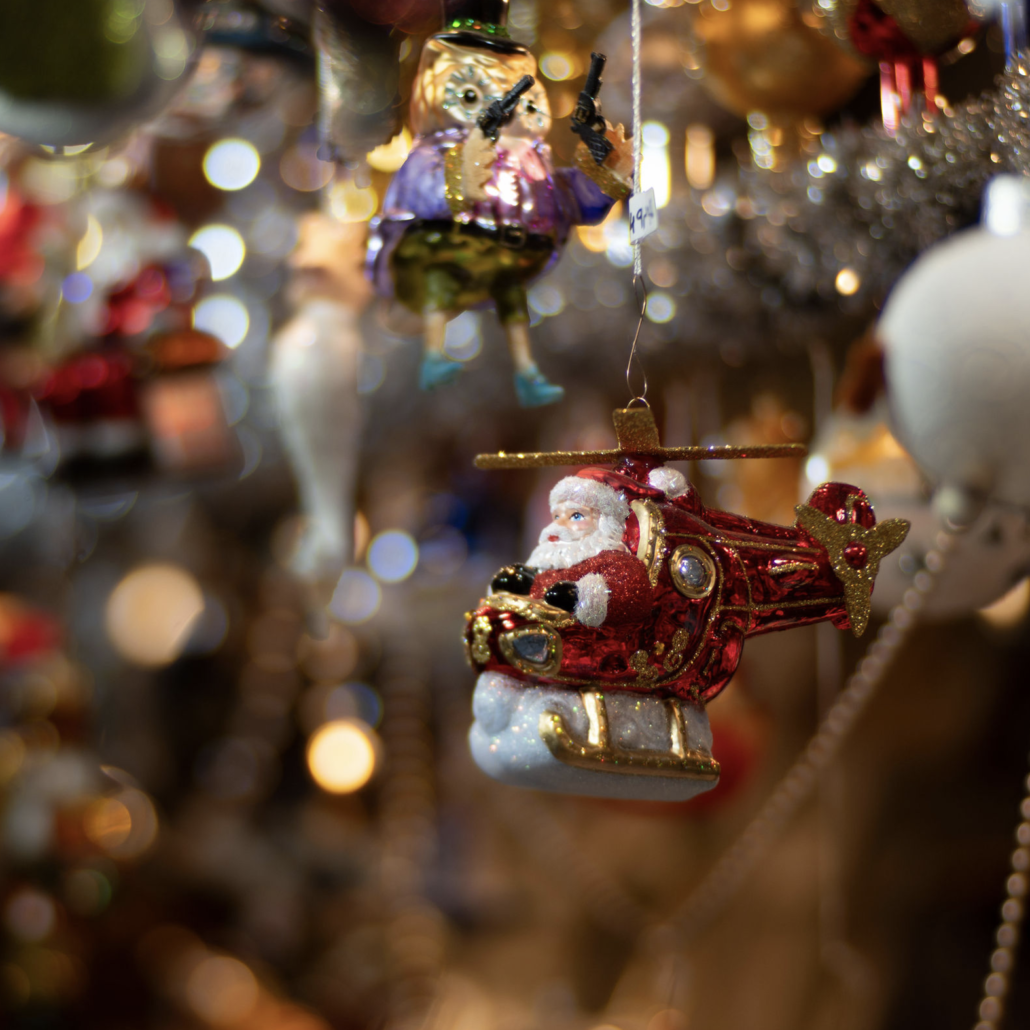A playful Christmas ornament Santa Claus in a red helicopter Christmas ornament surrounded by sparkling decorations