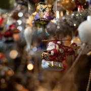 A playful Christmas ornament Santa Claus in a red helicopter Christmas ornament surrounded by sparkling decorations