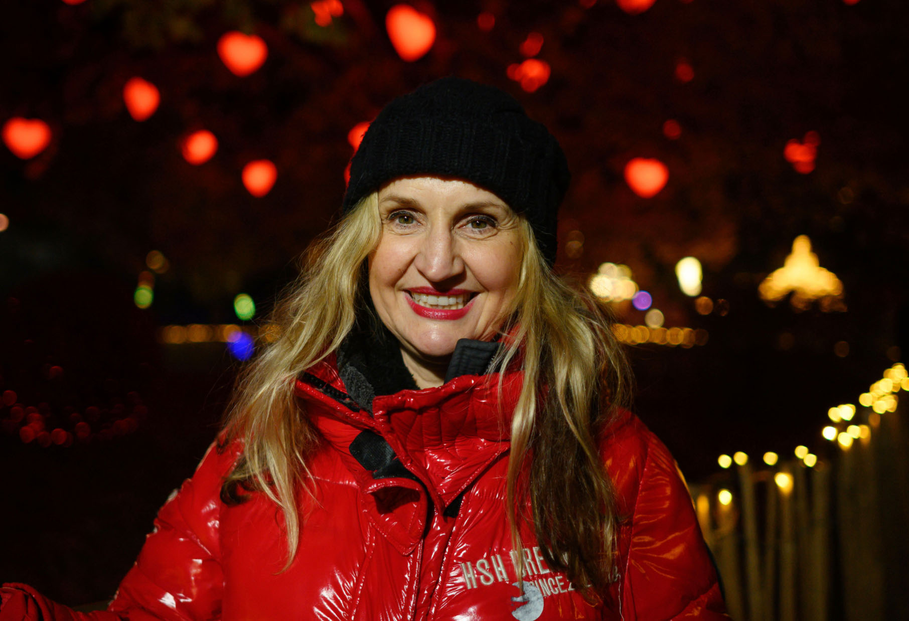Susanne Waldeck in a red jacket with Christmas lights in Vienna